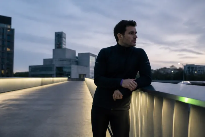 AI video ad: a runner pausing on a city bridge at dawn.